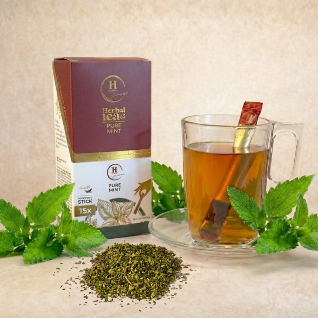 Pure Mint stick tea termékkép: doboz, üvegcsésze teával és stick, friss menta levelekkel.